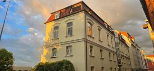 a large white building with a red roof at Zentrumsnahe Apartments an der Bucht in Rostock