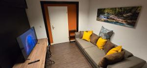 a living room with a couch and a flat screen tv at Zentrumsnahe Apartments an der Bucht in Rostock