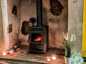 TrevorにあるMynydd A Mor, Mountains And Seaの蝋燭付きの部屋の薪ストーブ