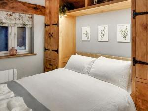 ein Schlafzimmer mit einem großen weißen Bett und zwei Fenstern in der Unterkunft 13 Doomgate Cottage - Uk45056 in Appleby