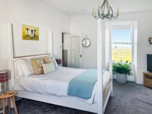 een witte slaapkamer met een bed en een raam bij Muirston Farmhouse - Uk44977 in Ochiltree +16 foto's