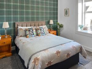 een slaapkamer met een bed met kussens erop bij Muirston Farmhouse - Uk44977 in Ochiltree