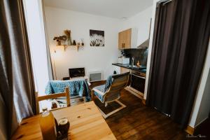 een woonkamer met een tafel en een keuken bij La bogue in Vals-les-Bains +8 foto's