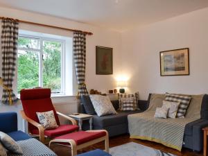 a living room with a couch and chairs and a window at Burrills View in Horderley
