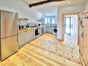 a kitchen with a stainless steel refrigerator and wooden floors at Dornfelder - Ukc3209 in Newbridge