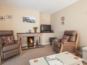 ein Wohnzimmer mit zwei Stühlen und einem Kamin in der Unterkunft Island View - Cottage in Aberdaron + 10 Fotos