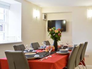een eetkamer met een tafel met een vaas met bloemen bij Hedderwick House in Pittenweem