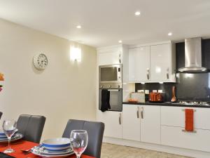 een keuken met witte kasten en een tafel met wijnglazen bij Hedderwick House in Pittenweem