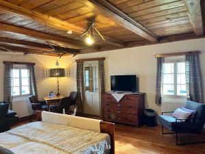 a living room with a bed and a desk and a television at Landgasthof Marhube in Baldramsdorf