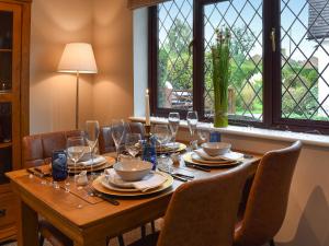 a wooden table with glasses and plates on it at Havre De Calme in Halstead