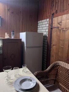 a table with a white plate and a refrigerator at Kuća za odmor Sremac in Apatin