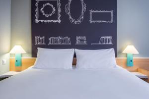 a bedroom with a large bed with two white pillows at Ibis Szczecin Centrum in Szczecin
