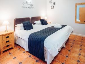 a bedroom with a large white bed with blue pillows at Gardener's Cottage - Uk6713 in Lydstep +10 photos