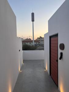 ein Balkon mit einer roten Tür an einer weißen Wand in der Unterkunft سَروة للوحدات السكنية in Abha