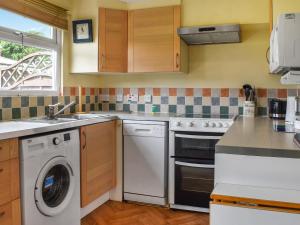 eine Küche mit einer Waschmaschine und einem Geschirrspüler in der Unterkunft Cat's Cove - Uk47720 in Saint Merryn
