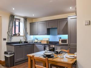 South KilvingtonにあるTanfield Barnの木製テーブル付きのキッチン、テーブル席付きのキッチン