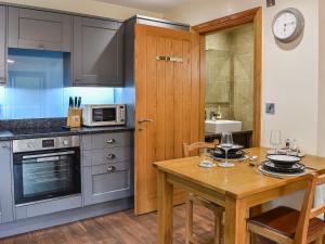 South KilvingtonにあるTanfield Barnの木製のテーブルと木製のドア付きのキッチン