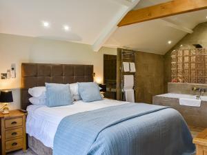 South KilvingtonにあるTanfield Barnのベッドルーム(大型ベッド1台、バスタブ付)
