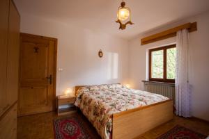 una camera da letto con un letto e una finestra di Appartamenti Sergio Benedetti a Sappada