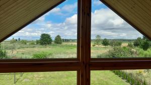 een raam met uitzicht op een veld vanuit een huis bij Villa Leone in Nowe Warpno