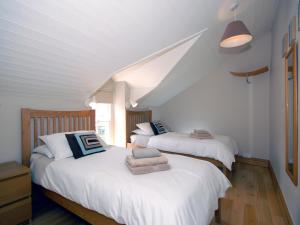 zwei Betten in einem Zimmer mit weißen Wänden in der Unterkunft Cerniw - Cottage in Aberaeron + 17 Fotos