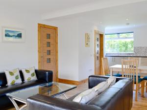 a living room with a leather couch and a table at Torsa - 28790 in Clachan