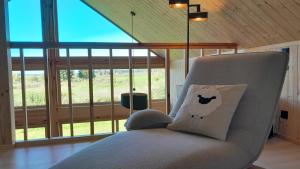 een stoel met een kussen in een kamer met ramen bij Villa Leone in Nowe Warpno