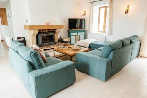 a living room with two blue couches and a fireplace at Le Logis du Vieux Donjon in Châteaumur