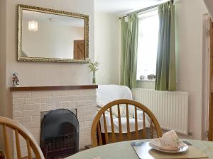 a living room with a fireplace and a table with chairs at Amberley Cottage in Alfreton