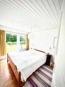 a bedroom with a bed in a room with a window at Get Close To Nature And The Starry Sky in Stege