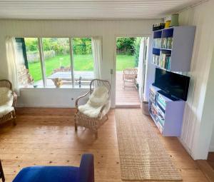 a living room with a tv and a book shelf at Get Close To Nature And The Starry Sky in Stege