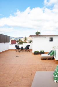 a patio with chairs and a table on a roof at La Centenaria 1920 in Telde