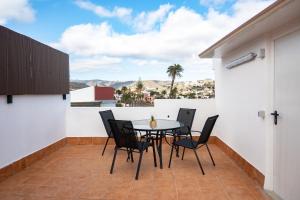 a patio with a table and chairs on a balcony at La Centenaria 1920 in Telde