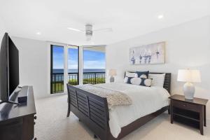 a bedroom with a large bed and a television at Elegant Three-Bedroom Oceanfront Apartment with Designer Finishes in South Palm Beach