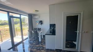 Una habitación con una mesa y sillas y un balcón. en LUXE 1 Venezia Suite, en Obzor 6 fotos más