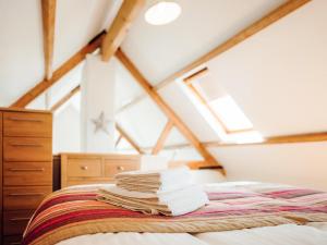 a pile of books on a bed in a attic at Flemish Cottage - Uk6720 in Lydstep +9 photos