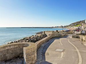a stone wall next to the water with a beach at The Pocker Watch in Chideock