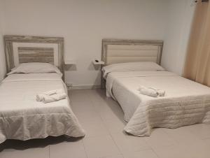 Cette chambre dispose de 2 lits et de carrelage blanc. dans l'établissement Pensión Alicante Playa, à Alicante