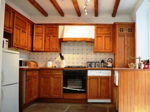 een keuken met houten kasten en een kookplaat met oven bij Church Walk Cottage in Kendal