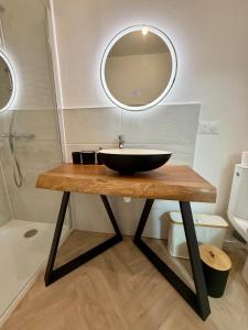 a bathroom with a black bowl sink on a wooden table at Casa Mérida in Saint-Jean-dʼAngély +11 photos