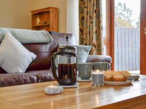 eine Kaffeekanne auf einem Tisch mit Essen darauf in der Unterkunft Old Mill Cottage in Blair Atholl