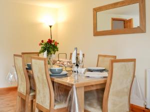 einen Esstisch mit Stühlen und einem Spiegel in der Unterkunft Old Mill Cottage in Blair Atholl