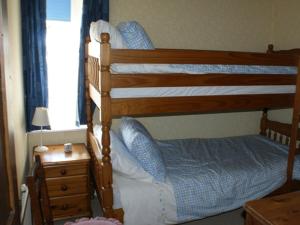 a bedroom with a bunk bed and a dresser with a night stand at Shore Cottage in Silverdale