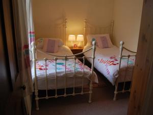 two twin beds in a room with two lamps at Shore Cottage in Silverdale