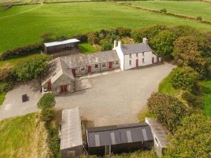 vue aérienne d'un grand bâtiment blanc aux portes rouges dans l'établissement Ffynnonddewi Farmhouse - Qc1535, à Llanhowell