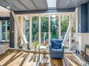 a living room with a blue chair and a fireplace at The Berm - Uk41199 in Llanfynydd