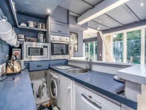 a kitchen with a sink and a washing machine at The Berm - Uk41199 in Llanfynydd