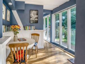a dining room with blue walls and a table and chairs at The Berm - Uk41199 in Llanfynydd