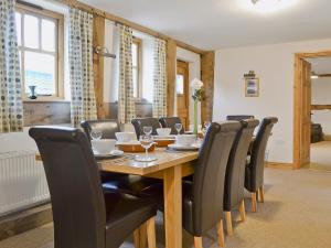 a dining room with a wooden table and chairs at The Olde Granary - E4298 in Halston