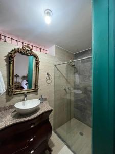 a bathroom with a sink and a glass shower at Paraíso Real in Buga